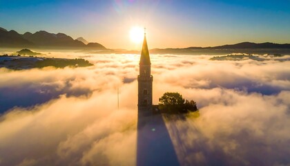 Spired tower rising above fog, golden sunrise behind. Mountains in background. Serene and ethereal, peaceful vista