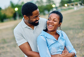 Obraz premium Happy young black couple having fun and hugging in park outdoors
