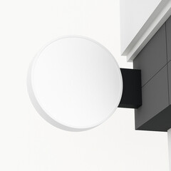 A blank white round sign mockup projecting from a modern building facade, ready for branding or information display.