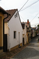 Charming alley with small traditional houses, red roofs, and cobblestone pavement in Zemun, Belgrade