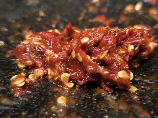 Fresh, spicy red chili paste, a traditional Indonesian condiment dish. Made from fresh red chilies, onions, and other spices ground in a stone mortar, it adds a spicy and savory flavor to any dish.
