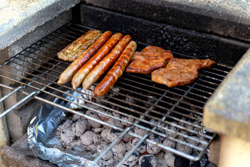 sausages and steaks are cooked on the grate on an old rustic grill