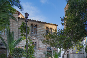 Obraz premium Historic Byzantine church facade with palm trees in Athens, Greece, showcasing cultural heritage, architecture, and Mediterranean style