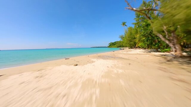 High-speed FPV drone flight skimming over turquoise cean water.