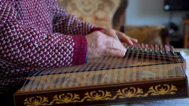 old man playing traditional turkish instrument qanun