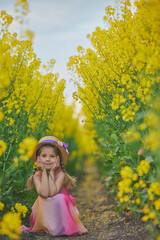 charming child in sundress in a rapeseed field