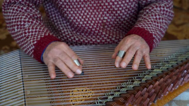 old man playing traditional turkish instrument qanun