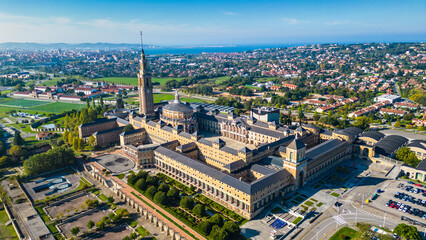 Fototapeta premium An impressive historic tower stands tall, offering a panoramic view of the vibrant coastal city of Gijon and its expansive bay under a clear blue sky.