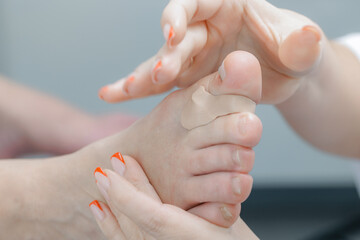 Female adult foot podiatrist treatment with elastic bandage and professional care protection against calluses