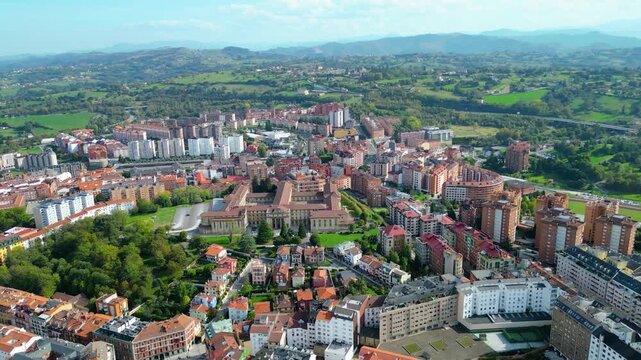 Aerial view of Oviedo, Spain, showcasing its historic architecture, bustling streets, and the iconic cathedral under clear autumn skies. A vibrant European city scene.