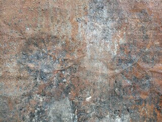 Rusty Concrete Surface Texture. A corroded concrete wall with rust stains, grey patches, and natural oxidation marks