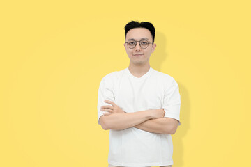 A young Asian man stands confidently against a yellow background © Freddy Chandra