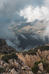 Moody mountain view with rugged rocks and dense clouds in the Puig Campana region, Spain. Perfect for nature, travel, adventure, and scenic landscape concepts.
