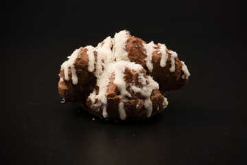 Profiteroles with coconut cream on a black background.