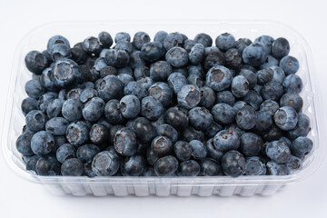 Blueberries in a plastic container isolated on a white background.