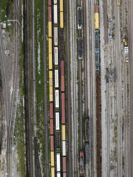 Trieste, Italy - 10 October 2025: Aerial view of colorful freight trains lined up on multiple tracks, a symphony of industrial hues against the stark grey of the railway yard.