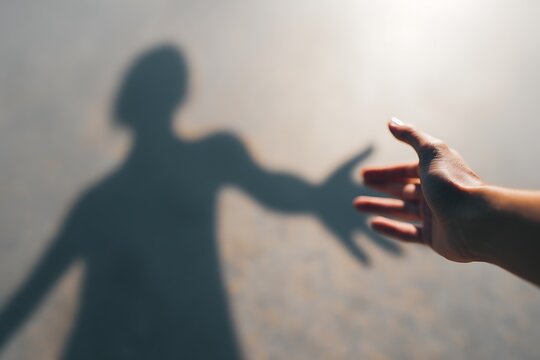 Human hand reaching out for shadow helping hand