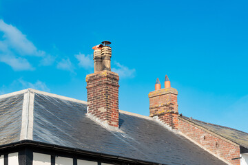 Old brick built chimneys seen on a victorian era home in the UK. Seen adjacent to a brick town...