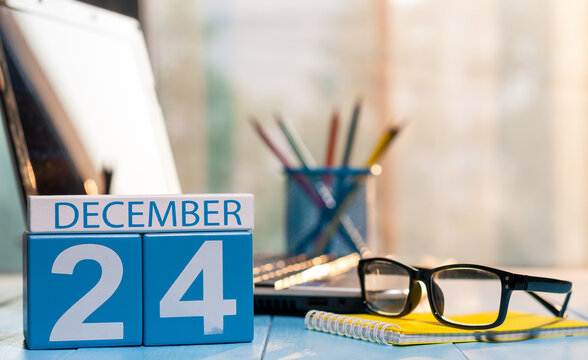 Wooden calendar block displaying December 24 on a modern office desk, symbolizing an important deadline or holiday period