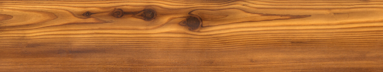 close-up of a brown wood texture with a visible grain pattern and several knots.natural wood plank or a surface, with a warm, reddish-brown hue.