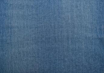 Close up of blue denim fabric texture showing detailed weave and subtle variations in color