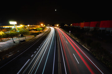 Dramatic light trails streak across a night highway offering a dynamic and modern urban scene perfect for transportation and technology concepts