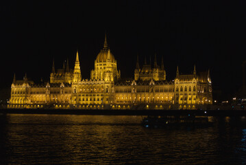 Fototapeta premium Hungarian Parliament in Budapest at night across the river Danube