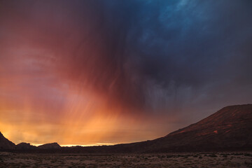 Dramatic sunrise with lenticular cloud formations and rainbow over Tenerife's volcanic landscape, ideal for nature documentaries, travel websites, and stock image sales
