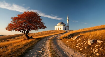 Picturesque view of a mosque atop a hill with a vibrant tree in the foreground