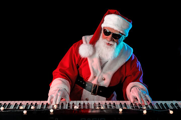 Santa Claus playing the electric piano in a nightclub at a Christmas and New Year party or...