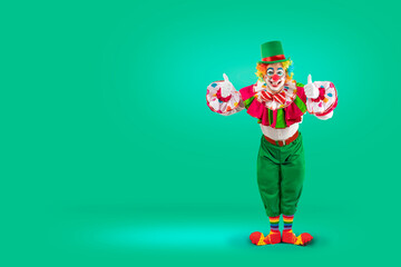 Funny clown thumbs up, man entertainer as Joker in a suit and wig, with clown whiteface makeup. Trickster, jester, pantomime, mime, and a professional actor at events.