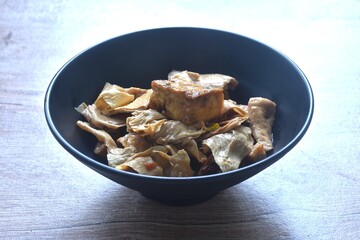 fried slice yellow tofu and gypsum with celery in soy sauce vegetarian food on bowl