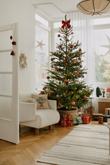 Christmas living room with a bright tree, wrapped gifts and cozy armchair.  Festive interior in red...