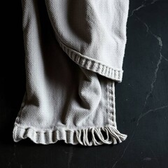 A photograph of a towel displaying an intense jet black cast bronze surface with an antique patina finish, pure black, and deep shadows