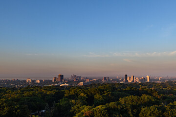 View of a section of the skyline of the city of Toronto, Ontario, Canada, as early morning sunlight casts a golden glow on tall buildings in the distance.
