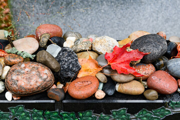Colorful stones placed by visitors to a Jewish grave. Mourners and visitors to a Jewish gravesite traditionally leave behind a small stone or pebble as a sign of their visit.