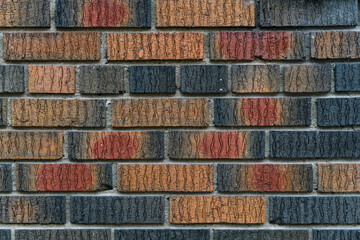 Abstract detail of multiple rows of multi-colored, textured bricks.