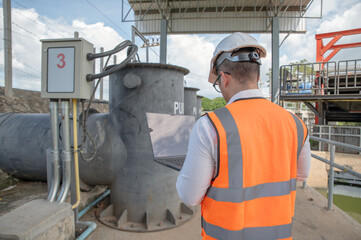 engineer is inspecting the area around the water control plant and inspecting the water storage tank