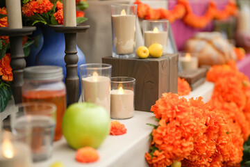 An artificial candle light with ancestor worship and group of decorated object on the table as blurred background. Life and death in Halloween festive scene. Close-up with selective focus. 