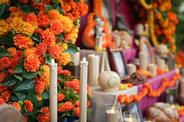 An artificial candle light with ancestor worship and group of decorated object on the table as blurred background. Life and death in Halloween festive scene. Close-up with selective focus. 