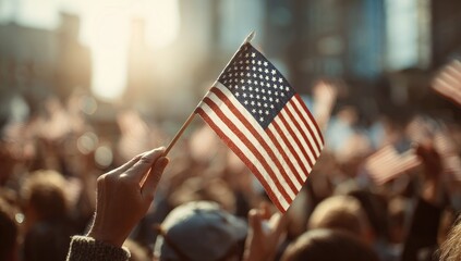 Hand holding American flag at a sunny outdoor gathering