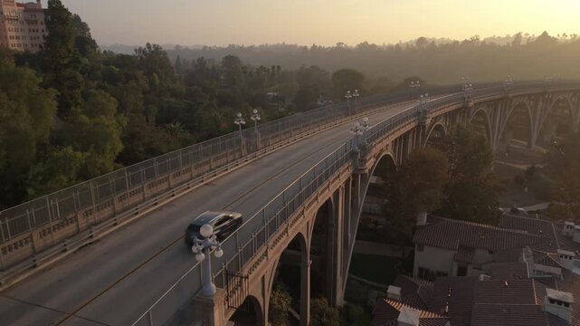 sunset flying along Pasadena's Colorado St. Bridge following cars