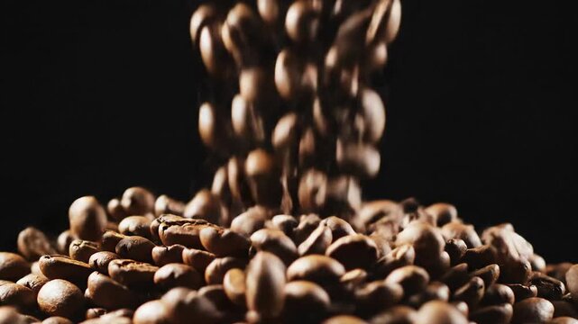 Falling roasted coffee beans in motion black background