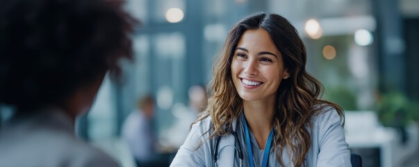 A smiling healthcare professional engages in conversation with a patient, showcasing a positive and friendly atmosphere in a medical setting.