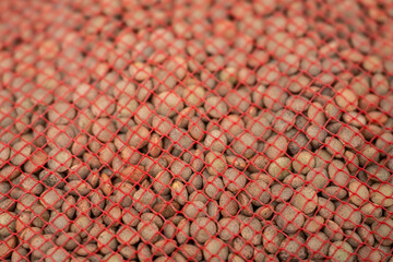A macro top down view of dry lentils seen through a red mesh bag The Concept of Healthy Food Storage