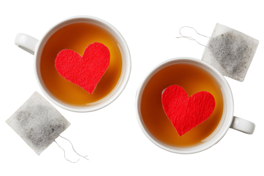 Two cups of tea with red hearts floating on top