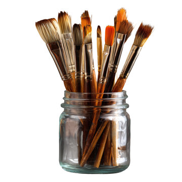 Assorted paintbrushes in a glass jar isolated