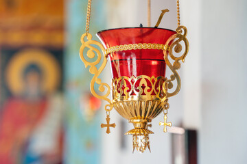 Golden church lamp with red glass in an Orthodox church
