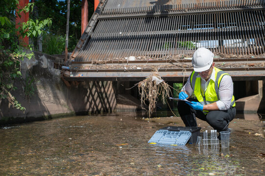 Water quality engineer collect water samples at the irrigation entrance, science is inspecting water