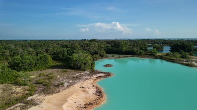 bintan islands blue lagoon also known as danau biru features striking turquoise waters surrounded by white sand hills creating a stunning contrast and serene tropical atmosphere